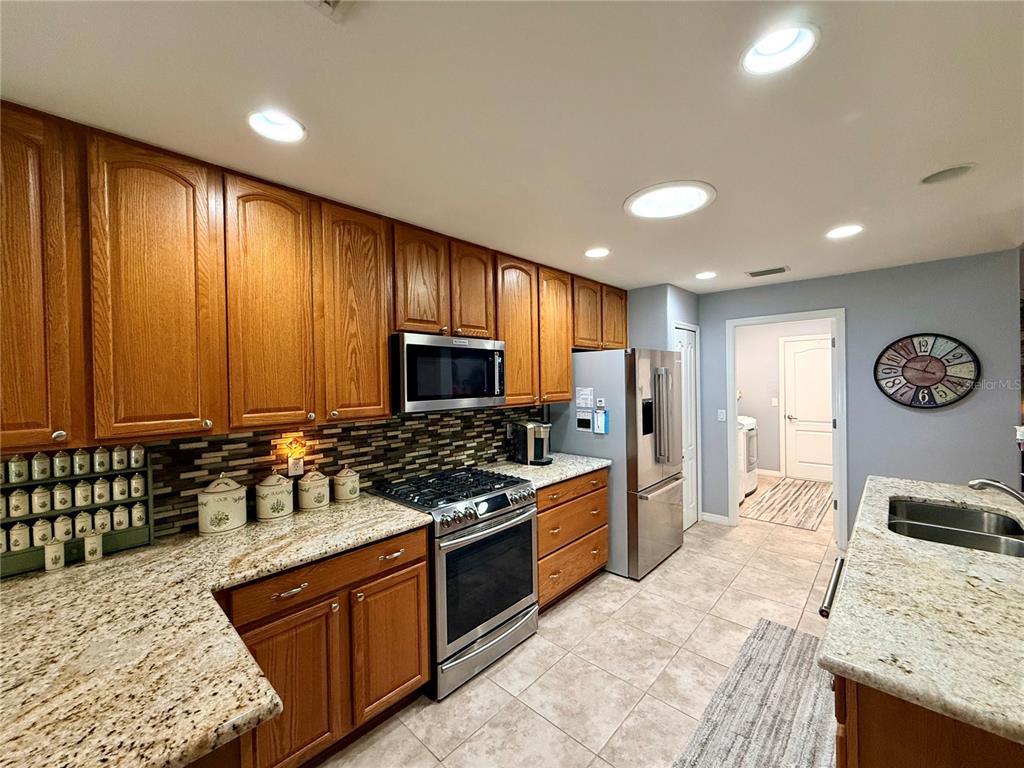 16296 Southwest 15th Court Ocala, FL 34473 - Photo 27 of 70 a kitchen with stainless steel appliances granite countertop a stove top oven a sink a counter space and cabinets
