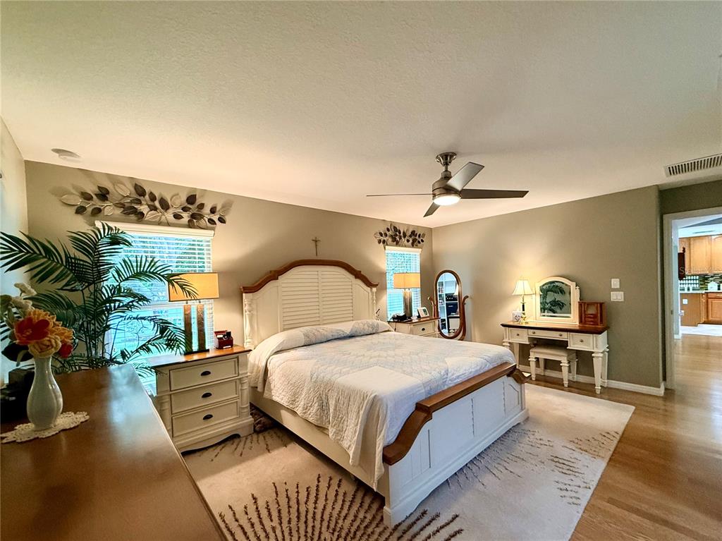 16296 Southwest 15th Court Ocala, FL 34473 - Photo 39 of 70 a bedroom with a large bed and a chandelier