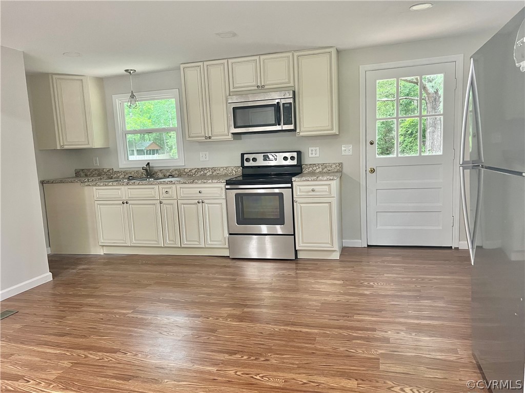 3440 The Loop Road Richmond, VA 23231 - Photo 5 of 22 a kitchen with granite countertop a stove a sink and a microwave