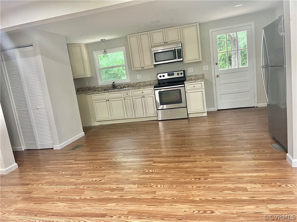3440 The Loop Road Richmond, VA 23231 - Photo 6 of 22 a kitchen with stainless steel appliances wooden cabinets and a wooden floor