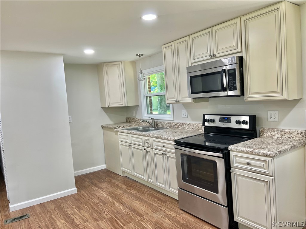 3440 The Loop Road Richmond, VA 23231 - Photo 9 of 22 a kitchen with stainless steel appliances granite countertop white cabinets a sink a stove a microwave and cabinetry
