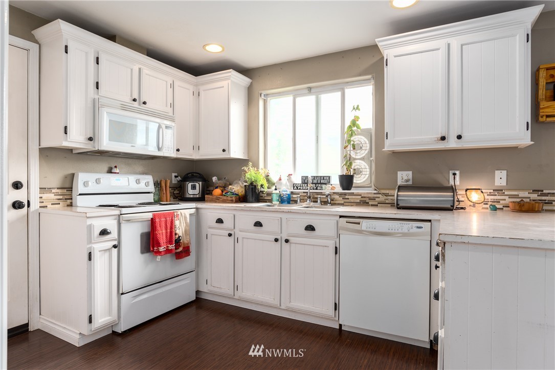 408 Rohrer Loop Sedro-Woolley, WA 98284 - Photo 6 of 20 a kitchen with stainless steel appliances granite countertop white cabinets sink and a window