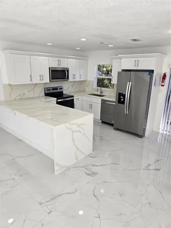 a kitchen with stainless steel appliances granite countertop a refrigerator sink and cabinets