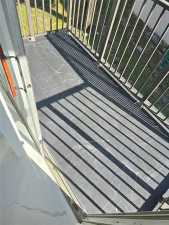 a view of a tennis ground with a table and chairs under an umbrella