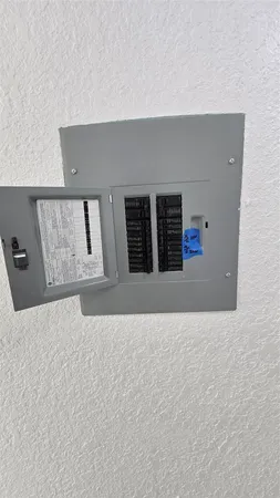 a view of road with card parked on side and retail shops