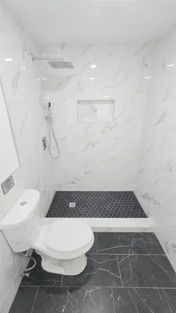 a bathroom with a toilet and a shower