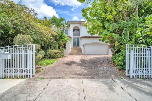 a front view of a house with plants and garden