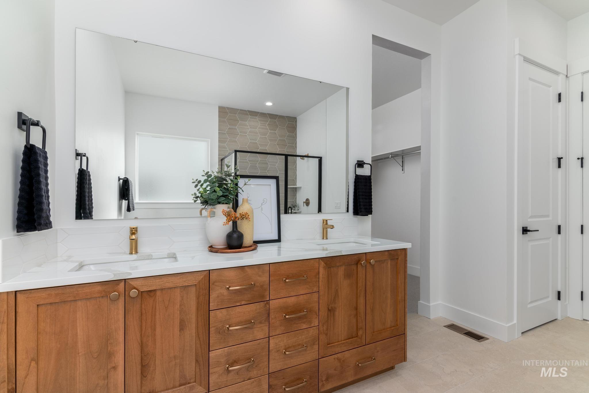 8569 South Silver Smog Way Meridian, ID 83642 - Photo 11 of 14 Bathroom with double vanity, light tile patterned floors, a shower stall, a spacious closet, and backsplash