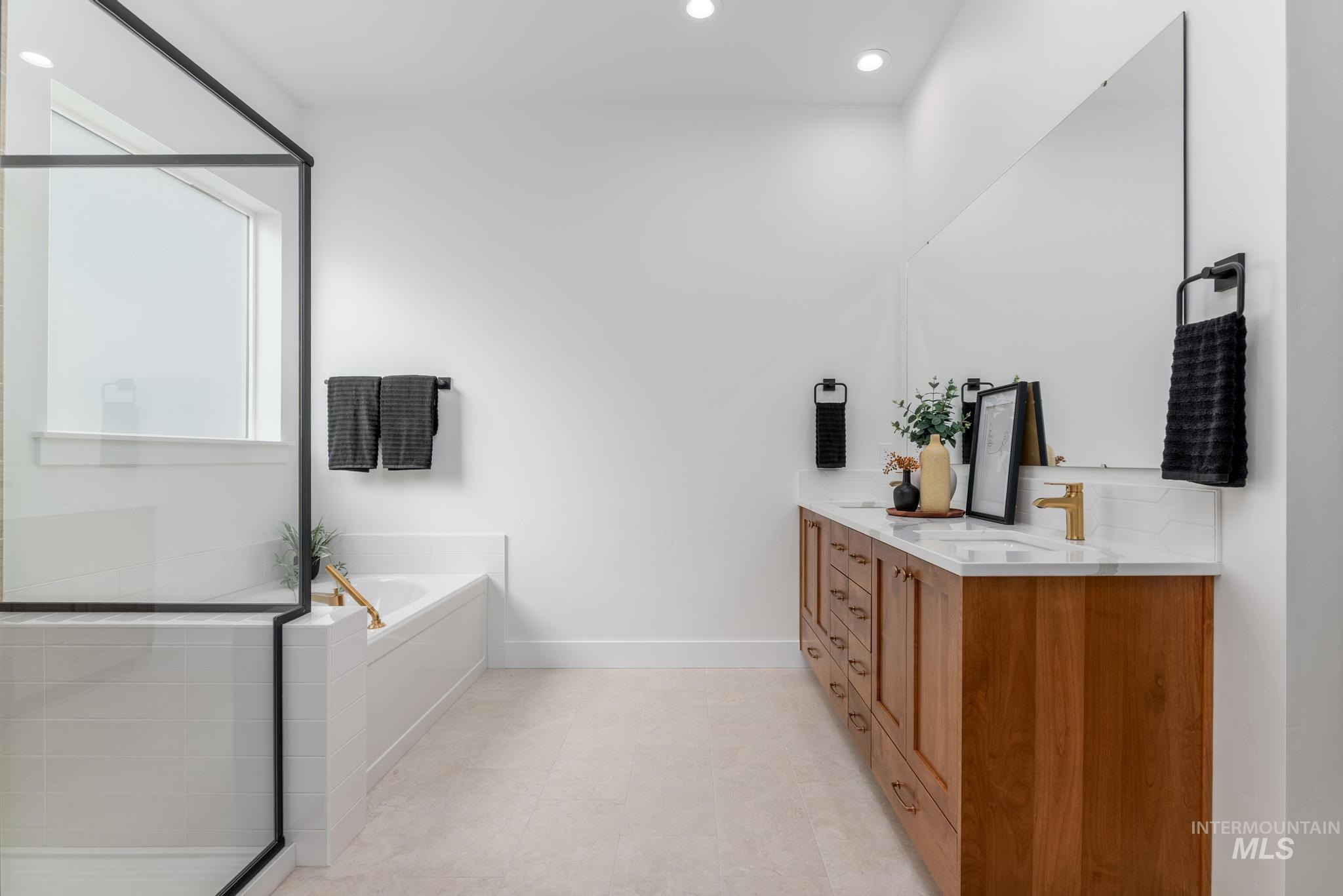 8569 South Silver Smog Way Meridian, ID 83642 - Photo 12 of 14 Full bathroom with double vanity, recessed lighting, a garden tub, and a stall shower