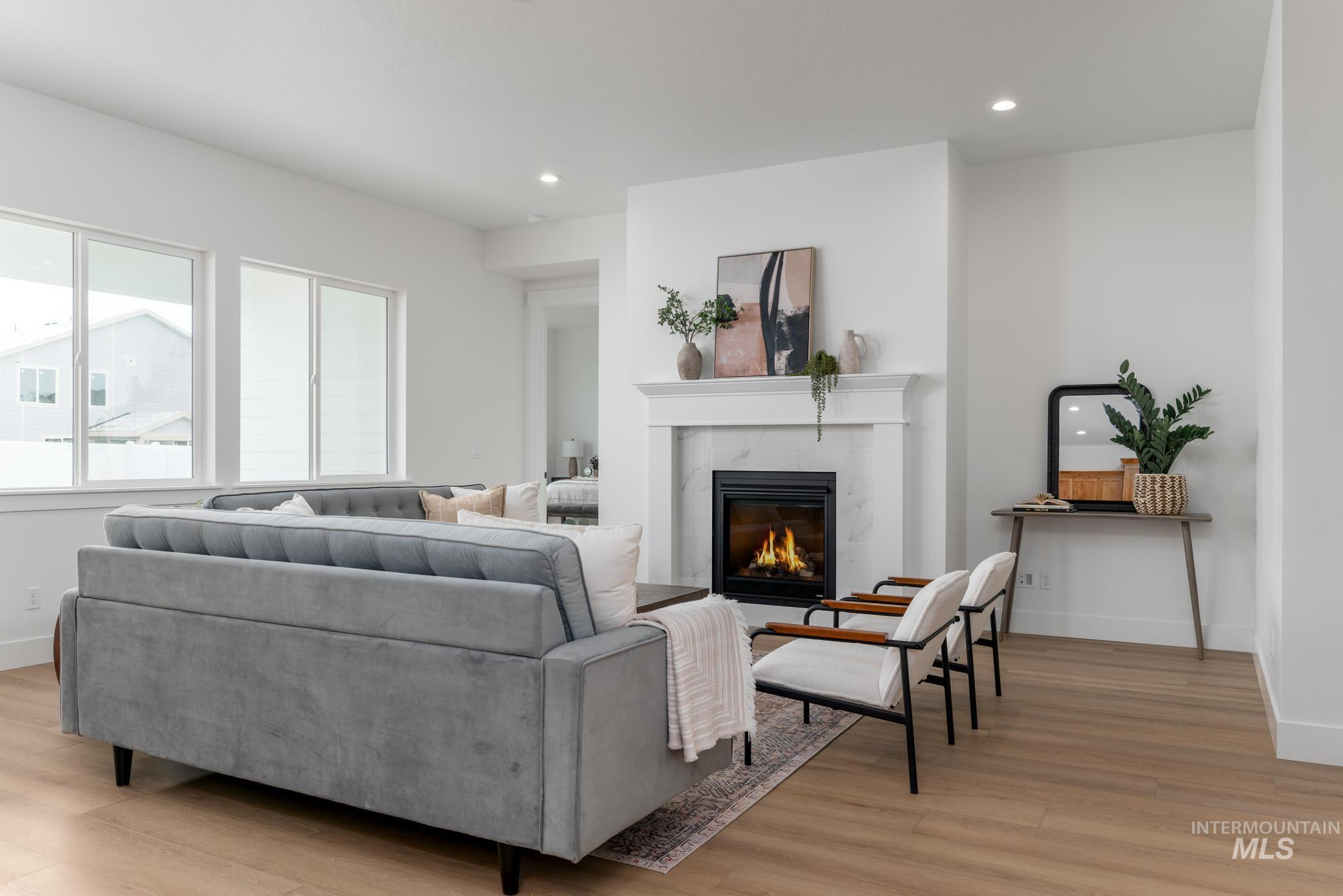 8569 South Silver Smog Way Meridian, ID 83642 - Photo 3 of 14 Living room featuring light wood-style floors, recessed lighting, and a high end fireplace