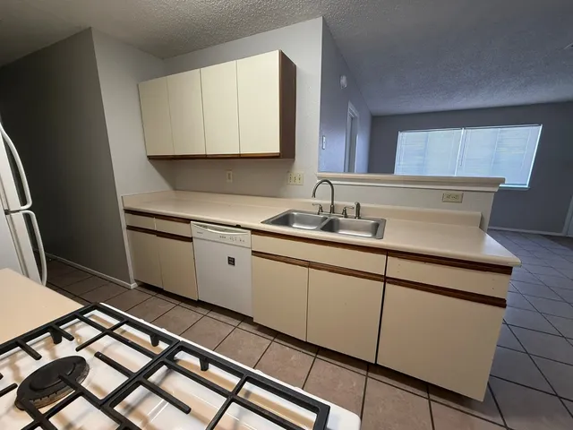a kitchen with a sink cabinets and appliances