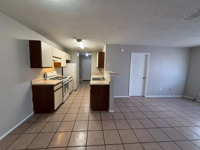 a kitchen with stainless steel appliances kitchen island granite countertop a refrigerator and a stove top oven