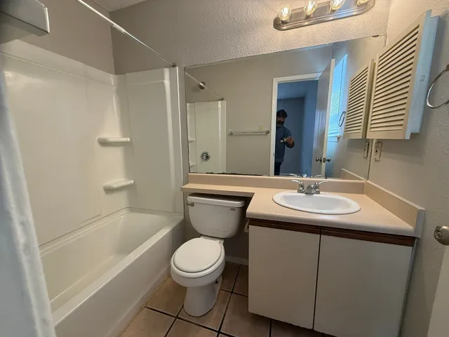 a bathroom with a toilet sink and mirror