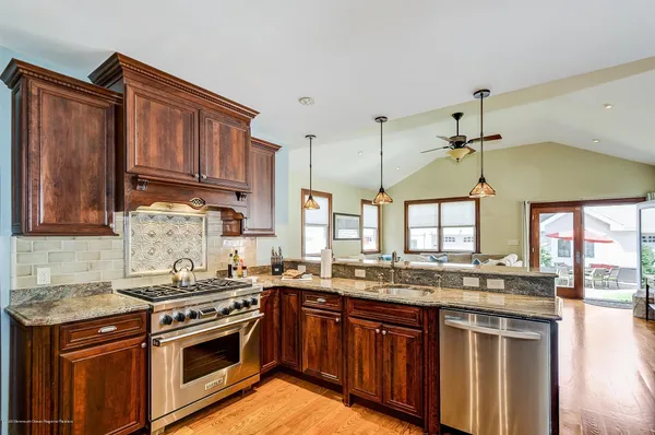 a kitchen with stainless steel appliances granite countertop a stove a sink and a microwave