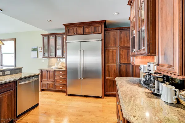 a kitchen with granite countertop a refrigerator and a sink