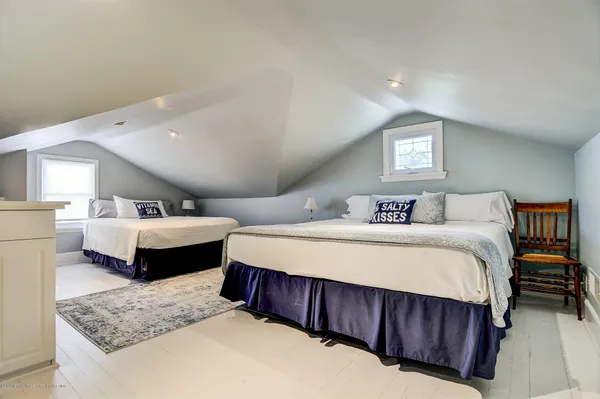 a spacious bedroom with a bed and wooden floor