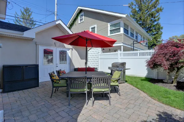 a view of a house with a table and chairs under an umbrella