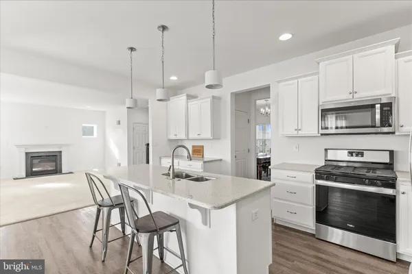 a kitchen with a stove a sink a dining table and chairs