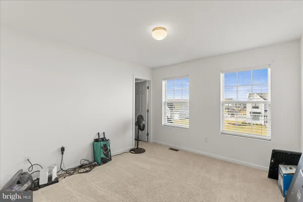 a view of an empty room with window and bathroom