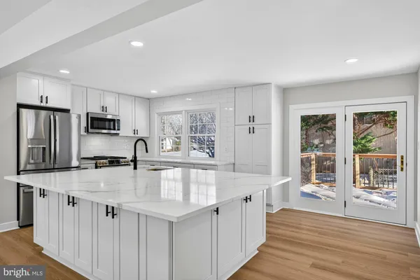 a large kitchen with stainless steel appliances granite countertop a lot of counter space and a sink