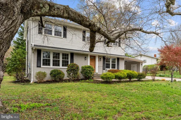 a view of a house with a yard and large tree