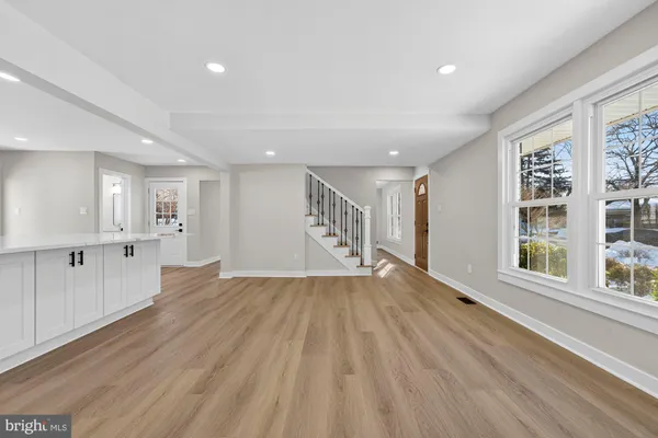 a kitchen with white cabinets a sink dishwasher and a stove with wooden floor