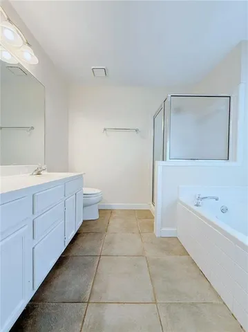 a spacious bathroom with a double vanity sink a mirror and a bathtub