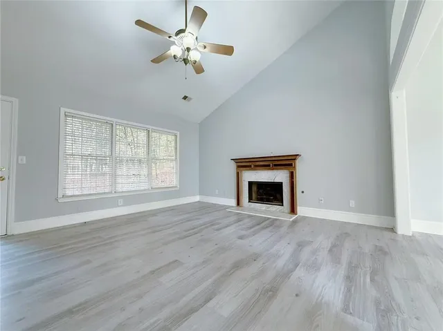 wooden floor fireplace and windows in an empty room