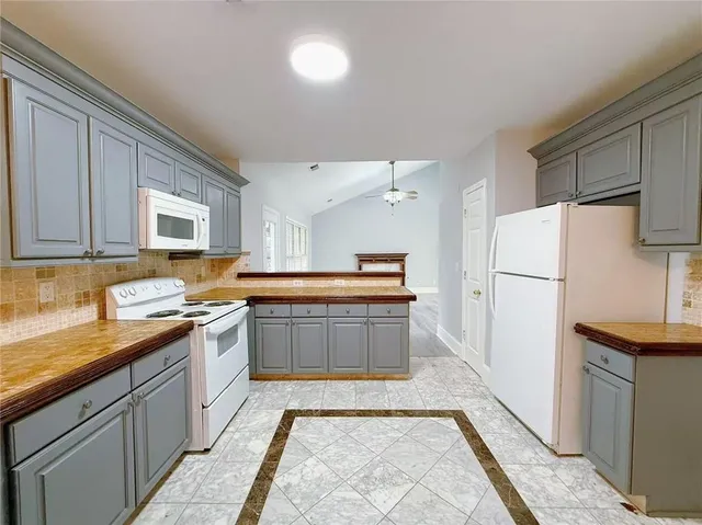 a kitchen with stainless steel appliances granite countertop a refrigerator a sink and a stove