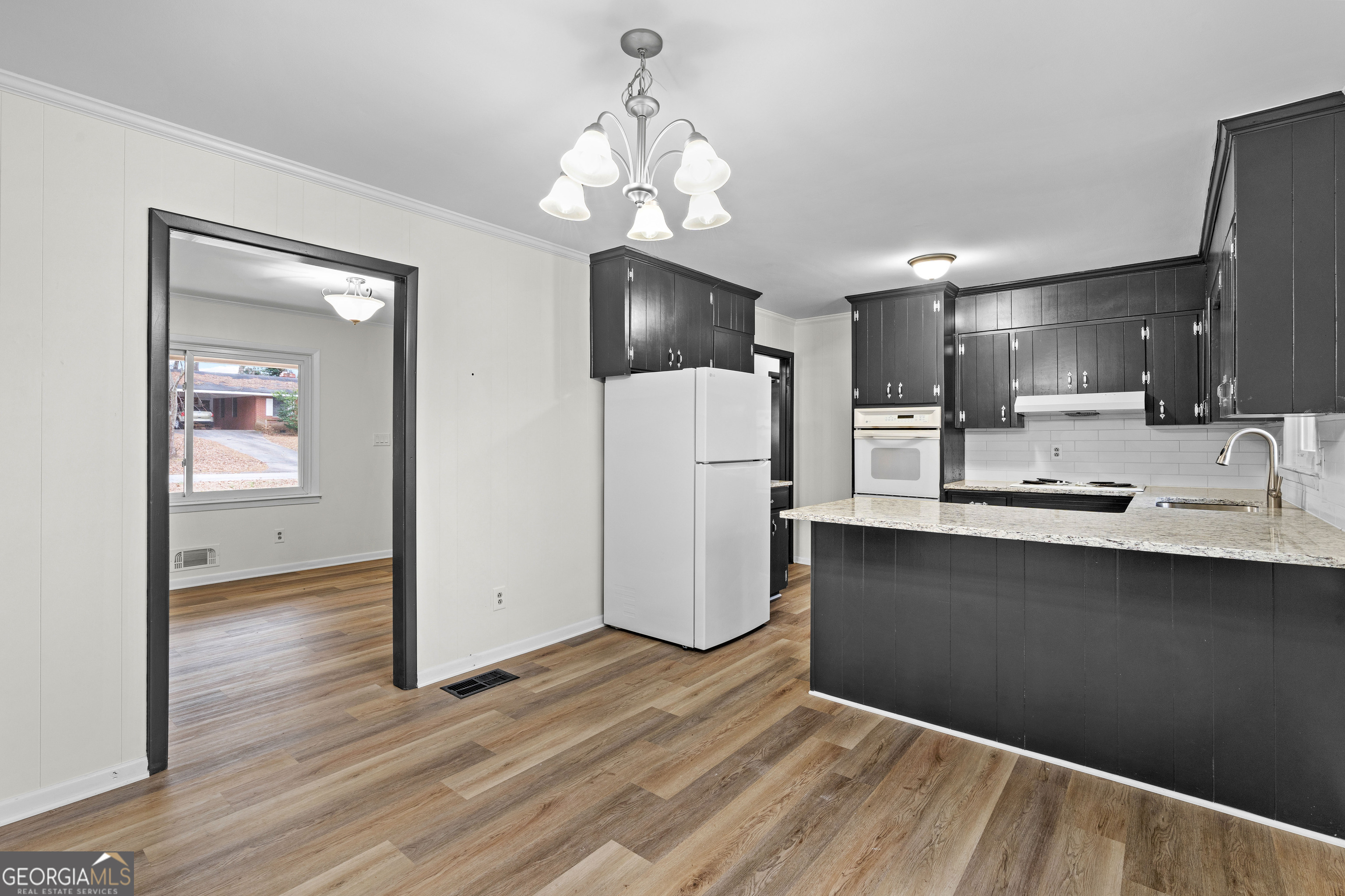 3548 Meadowview Court Rex, GA 30273 - Photo 12 of 41 a kitchen with stainless steel appliances granite countertop a refrigerator a sink dishwasher a stove and white countertops with wooden floor