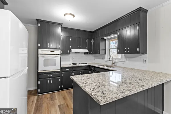 a kitchen with granite countertop a refrigerator and a sink