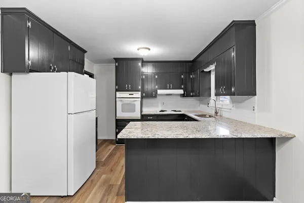 a kitchen with stainless steel appliances granite countertop a sink stove and refrigerator