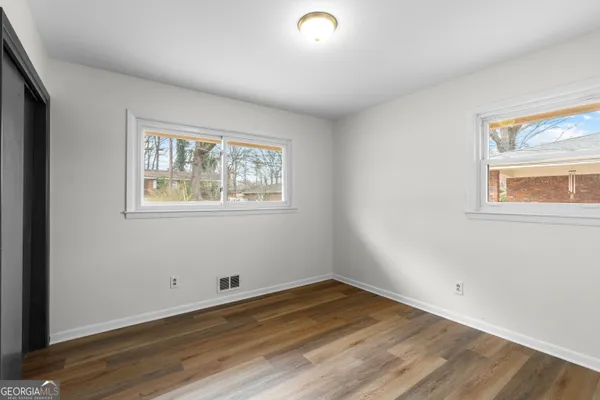 an empty room with closet and mirror