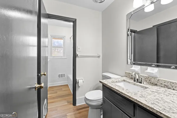 a bathroom with a granite countertop sink and a mirror