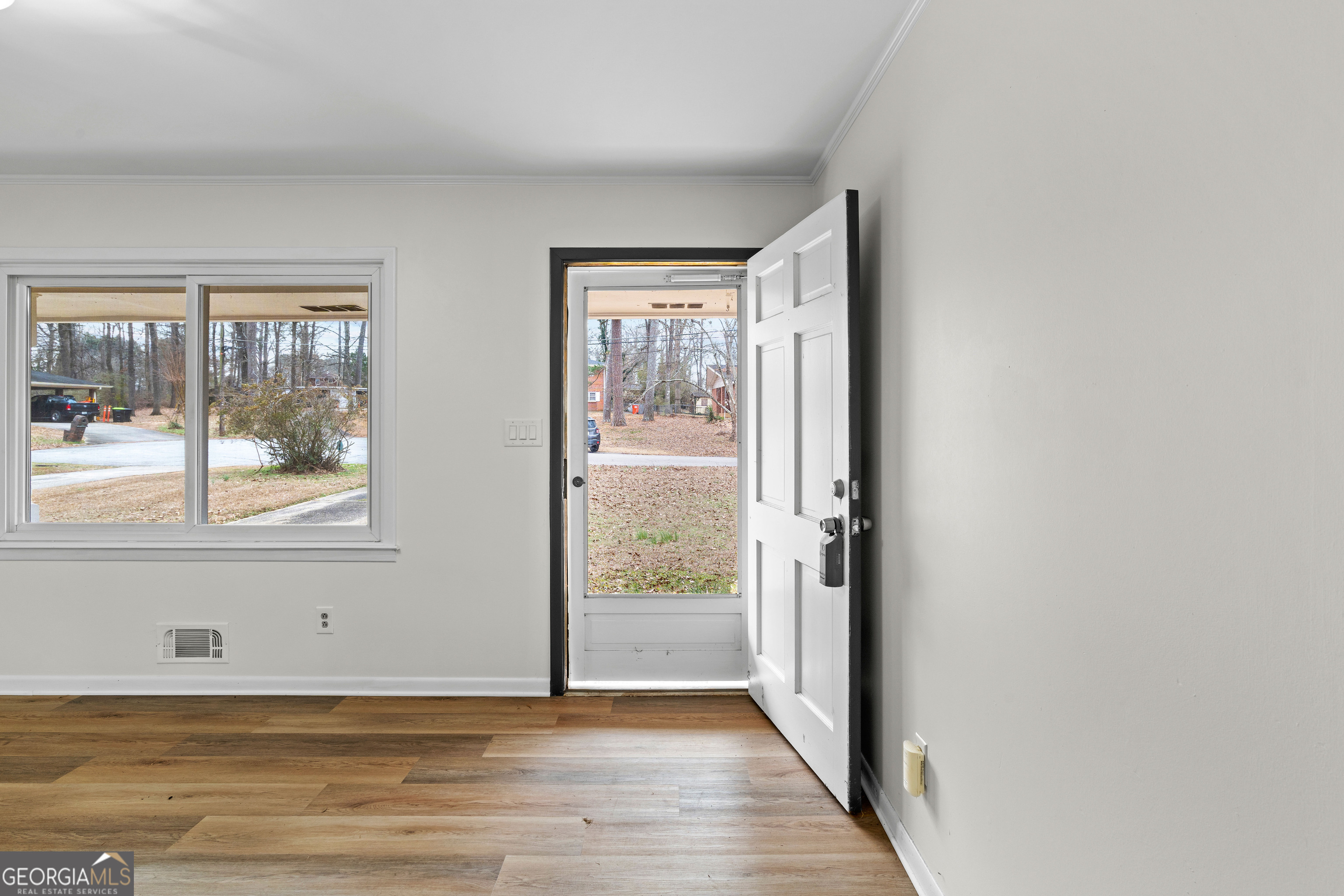 3548 Meadowview Court Rex, GA 30273 - Photo 5 of 41 a view of an empty room with wooden floor and a window