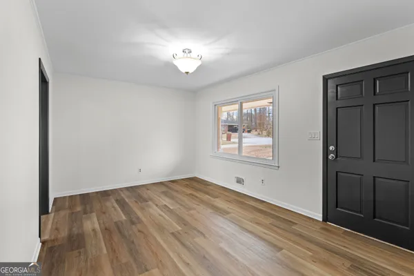 an empty room with wooden floor and a ceiling fan