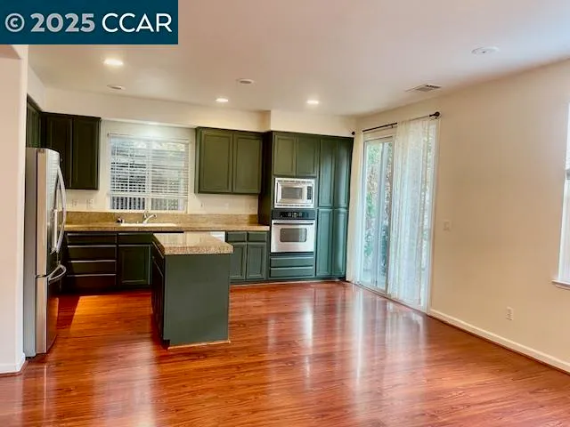 a kitchen with a refrigerator and a stove top oven