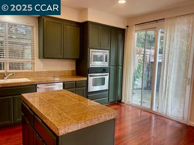 a kitchen with stainless steel appliances granite countertop a refrigerator and a sink
