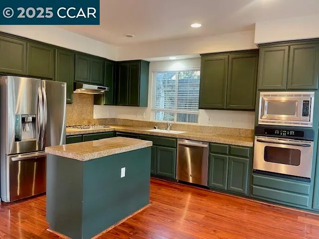 a kitchen with granite countertop a refrigerator and a sink