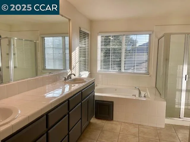 a bathroom with a granite countertop sink and a bathtub