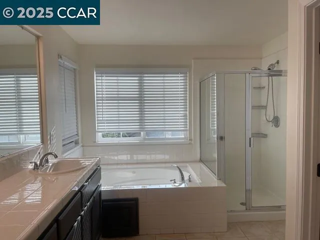 a bathroom with a tub a sink and a window