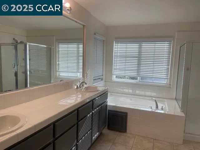 a bathroom with a granite countertop sink and a bathtub
