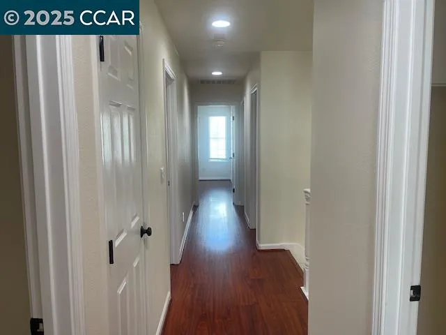 a view of hallway with wooden floor