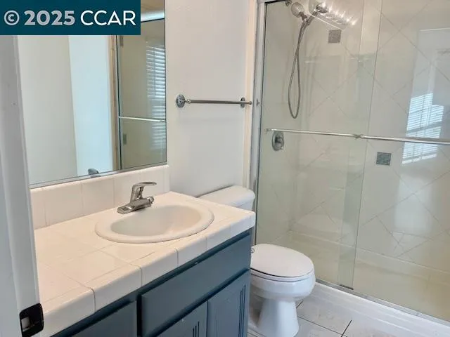 a bathroom with a granite countertop sink a toilet and shower