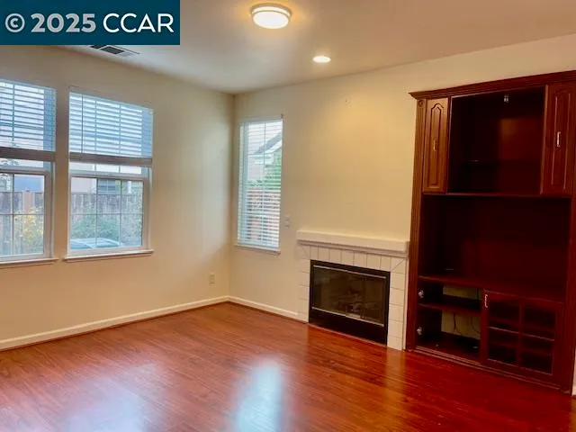 a view of empty room with wooden floor and fireplace