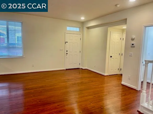 a view of an empty room with wooden floor