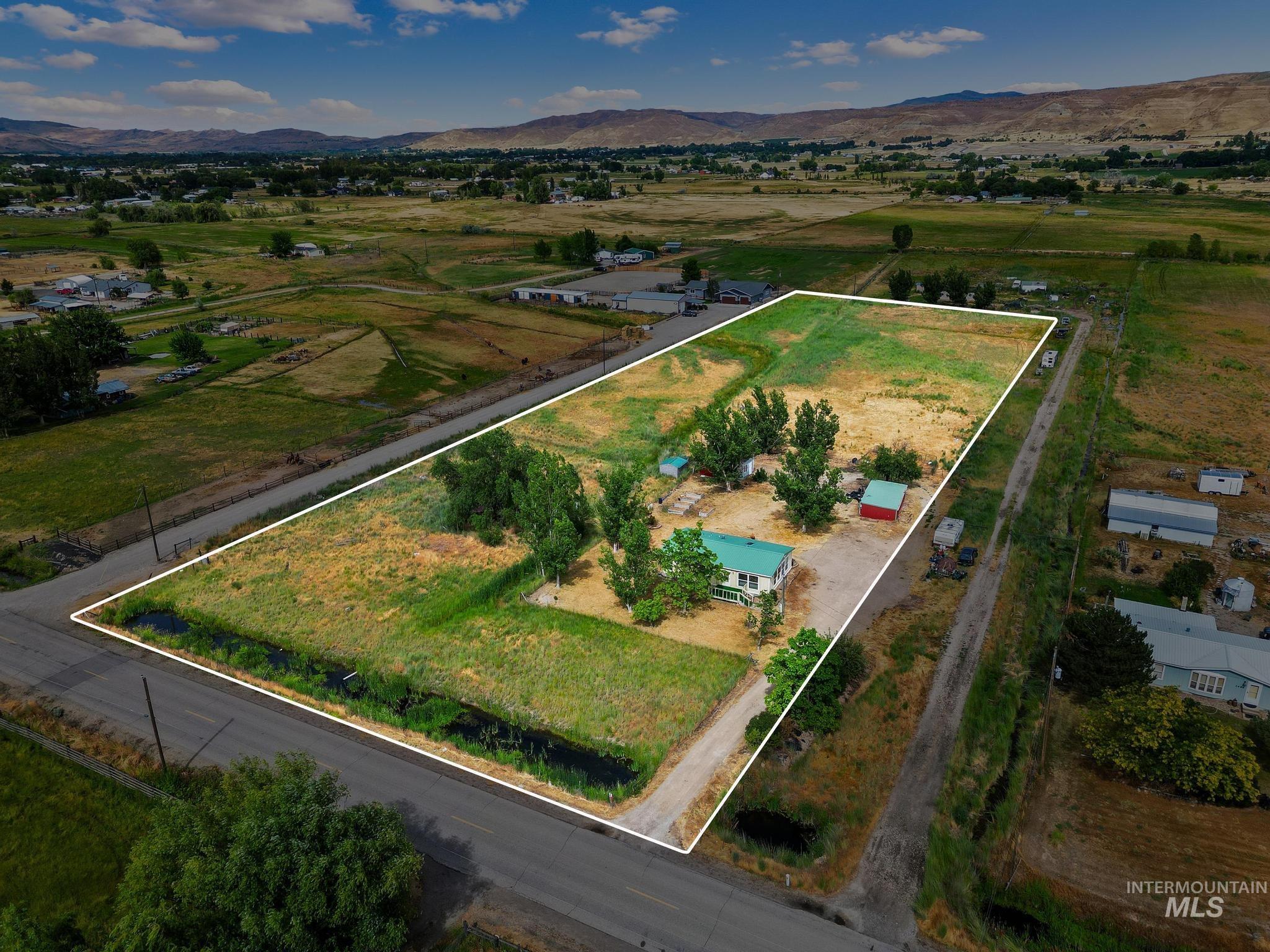 3680 South Mill Road Emmett, ID 83617 - Photo 33 of 38 Expansive lot featuring a residential structure with a green roof, multiple outbuildings including a red barn, and mature trees