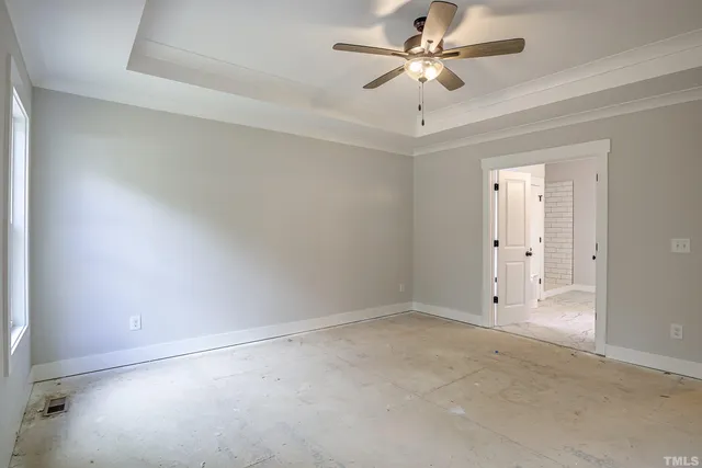 an empty room with wooden floor chandelier and windows