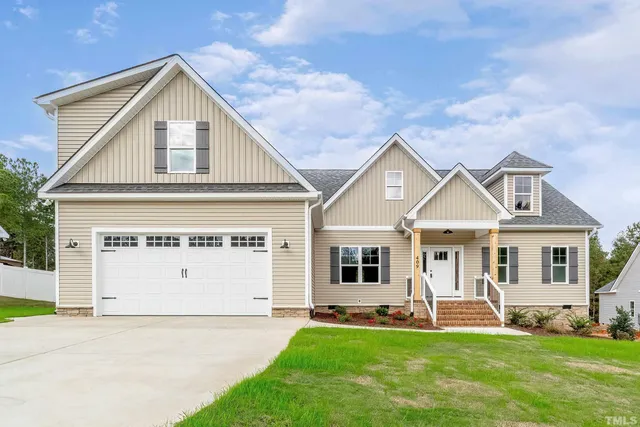 a front view of a house with a yard and trees