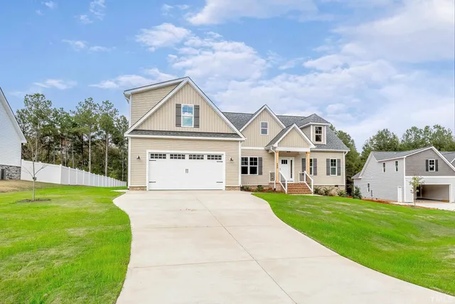 an empty room with wooden floor fireplace and staircase
